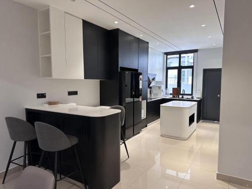 太平的住宿－Luxe J Homestay，厨房配有黑白橱柜和柜台。