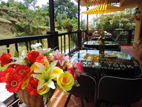 a table with a bouquet of flowers on a balcony at Oak Tree house in Guatapé