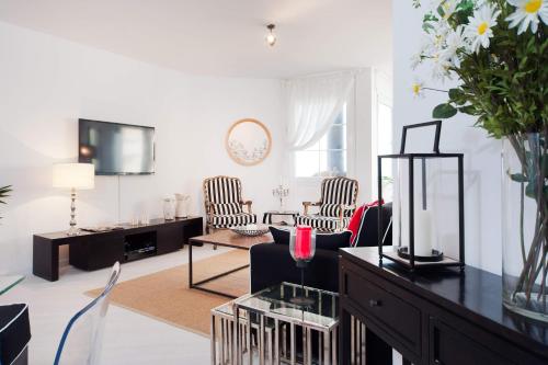 a living room with two chairs and a table at Chic 3BR Apt w Parking on the Beach by Sea N' Rent in Tel Aviv