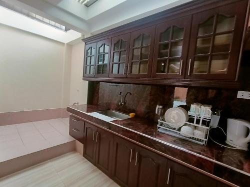 a kitchen with wooden cabinets and a sink at Raymundo Residence in Dumaguete