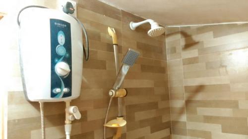 a shower with a remote control and a shower head at Big House Udawalawe in Udawalawe