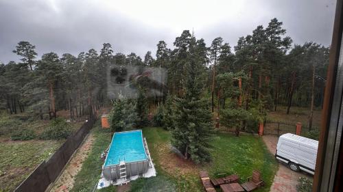 an aerial view of a swimming pool and trees at Osobnyak in Shchūchīnsk