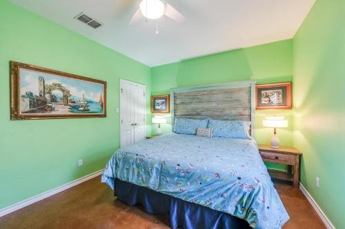 a bedroom with green walls and a bed with a wooden headboard at Pirates Bay #118 The LUV Shack poolfront townhome in Port Aransas