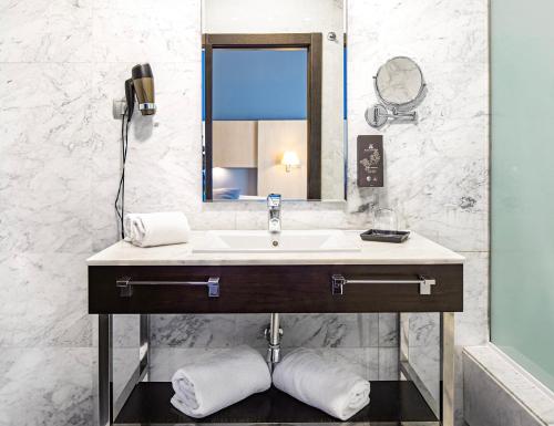 bagno con lavandino e specchio di Hotel Nuevo Boston a Madrid