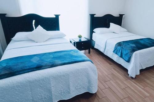 two beds sitting next to each other in a bedroom at Secure, central and quiet apartment work or travel in Mexico City