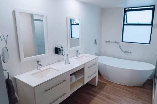 a white bathroom with a tub and a sink and a bath tub at Secure, central and quiet apartment work or travel in Mexico City