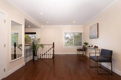 a living room with a staircase and a table and chairs at Westside Pool Home-8 min to Downtown, Yard Parking in Vancouver