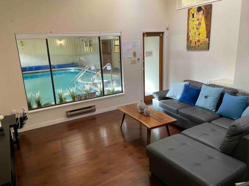 a living room with a couch and a table and a pool at Westside Pool Home-8 min to Downtown, Yard Parking in Vancouver