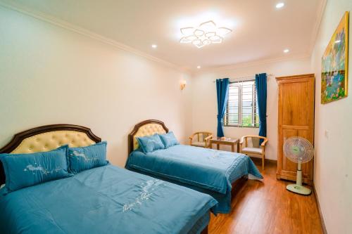 a bedroom with two beds and a fan at BAO AN RESORT & BUNGALOW in Hòa Bình