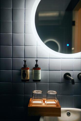 a bathroom with two jars on a shelf with a mirror at Heart Hotel in Limassol