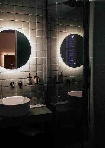 a bathroom with two sinks and two mirrors at Heart Hotel in Limassol