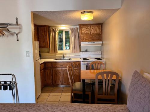 uma pequena cozinha com uma mesa e um lavatório em Timbers INN and Suites em Ashland