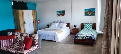een slaapkamer met een bed en 2 stoelen. bij appartement Villa Nancy in Toamasina