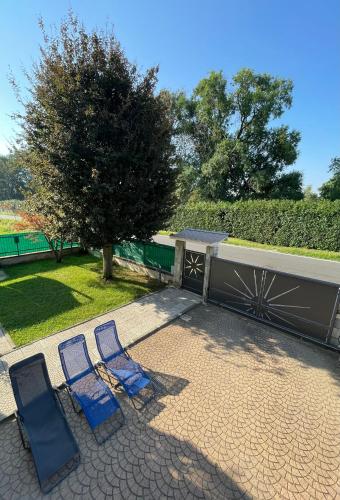 two blue chairs sitting on a patio next to a tree at IL Sole in Caselle Torinese