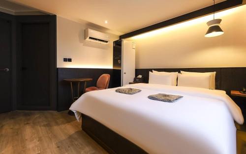 a hotel room with a large white bed and a table at STAY201 in Jecheon