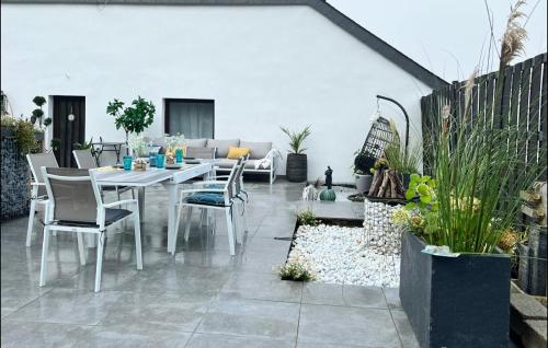 a patio with a white table and chairs at Le Clos fleuri in Fauvillers