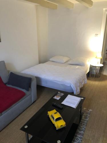 una habitación con una cama y un coche de juguete amarillo sobre una mesa en Victor Hugo 3D et sa pizza offerte en Aurillac