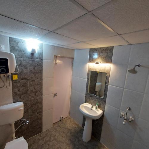 a bathroom with a sink and a toilet and a mirror at The skyline suite. in Lucknow