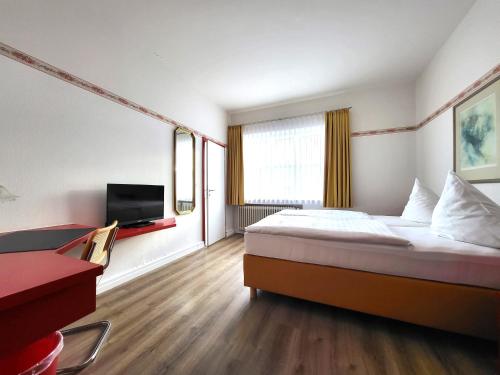 Habitación de hotel con cama y TV de pantalla plana. en City Hotel, en Delmenhorst