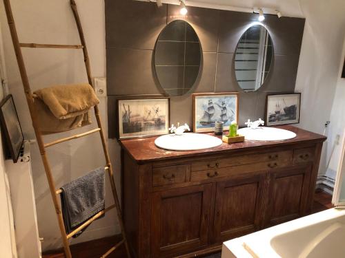 a bathroom with two sinks and two mirrors at Victor Hugo 2G et sa pizza offerte in Aurillac