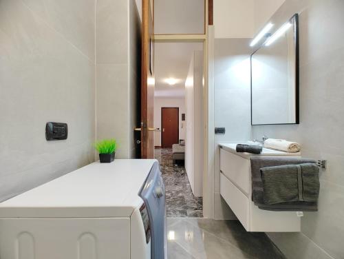 Baño blanco con lavabo y espejo en Primo Maggio en Udine