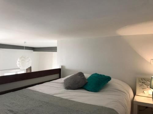 une chambre avec un lit avec deux oreillers dessus dans l'établissement Studio Mezzanine N Dame, à Versailles