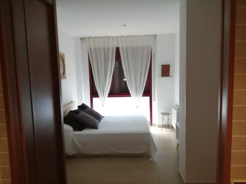 1 dormitorio con 1 cama frente a una ventana en APARTAMENTOSTACRISTINA, en Santa Cristina d'Aro