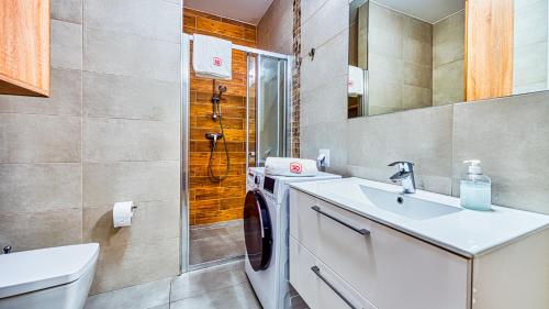 łazienka z umywalką i pralką w obiekcie Apartament 14 Nad Norweską Polaną z Basenem i SPA - 5D Apartments w Szklarskiej Porębie