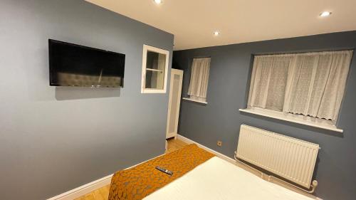 a living room with a flat screen tv on the wall at Apartment & Rooms in London in Croydon