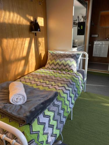 a bed sitting in a room next to a lamp at Ross Beach TOP10 Holiday Park in Ross