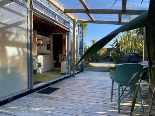 a patio with a table and chairs on a deck at Ross Beach TOP10 Holiday Park in Ross