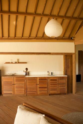a kitchen with wooden cabinets and a white ceiling at Modjo Apartment Bingin in Uluwatu