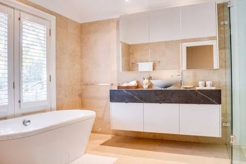 a bathroom with a sink and a toilet and a tub at Heritage Holiday House No.15 in Wonga Park