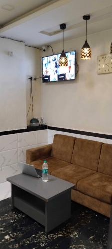 a living room with a couch and a tv at Hansh Residency in Mumbai