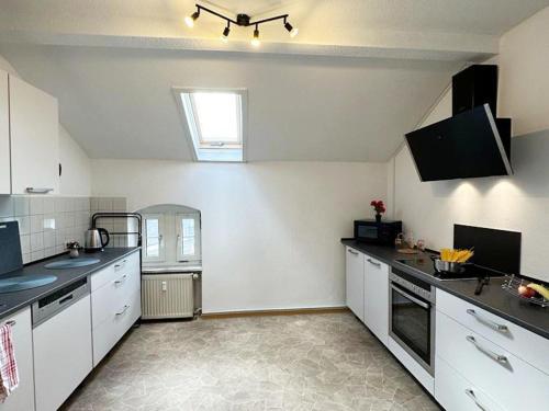 een grote keuken met witte kasten en een raam bij Spacious Apartment for Traveler and Fitter in Lollar