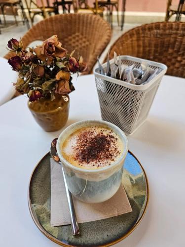 a cup of coffee on a plate on a table at Alux Boutique Hotel in Málaga