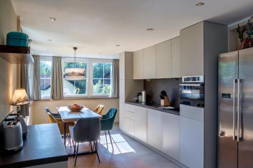 a kitchen with white cabinets and a table with chairs at Alpin Kanker Suites 1 in Garmisch-Partenkirchen