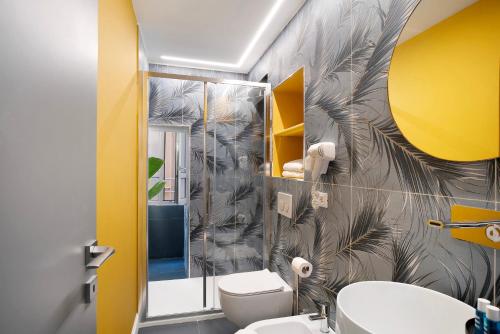 een badkamer met een toilet en een gele muur bij Loft 42 in Alassio