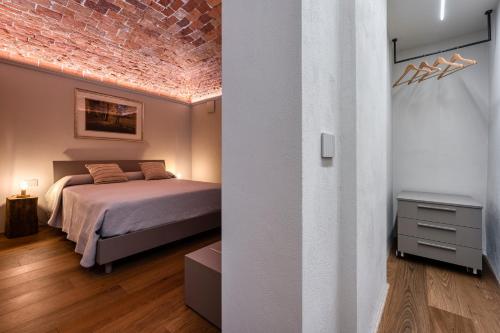 a bedroom with a bed and a brick wall at Casa Calleri in Briaglia