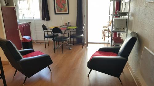 een woonkamer met stoelen en een tafel en een eetkamer bij Un pied à terre in Carcassonne