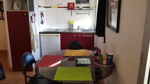 een keuken met een glazen tafel en stoelen in een kamer bij Un pied à terre in Carcassonne