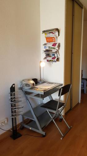 un bureau avec une lampe et une chaise dans une pièce dans l'établissement Un pied à terre, à Carcassonne