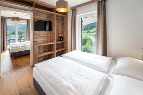 ein Schlafzimmer mit einem großen weißen Bett und einem Fenster in der Unterkunft Apartment Ski&Nature "Fanningberg" in Mauterndorf