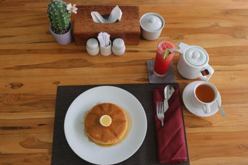 a plate of pancakes on a table with a cup of coffee at BALE DATU BUNGALLOW in Gili Trawangan