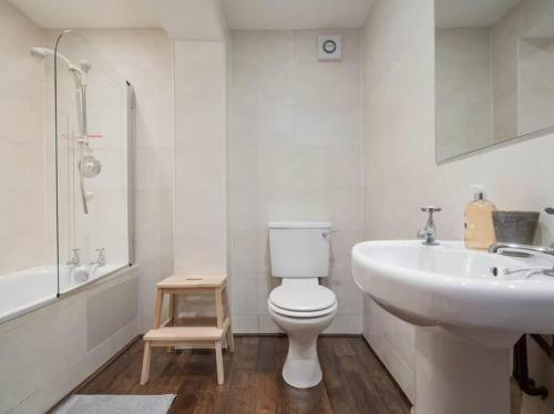 uma casa de banho branca com um lavatório e um WC e um lavatório em The Third em Edinburgo