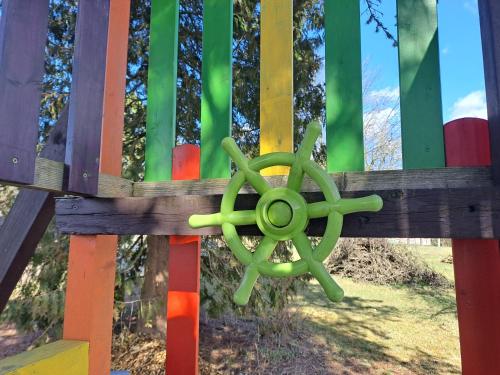 a wooden fence with a green wheel on it at Chata Pohádka in Česká Skalice