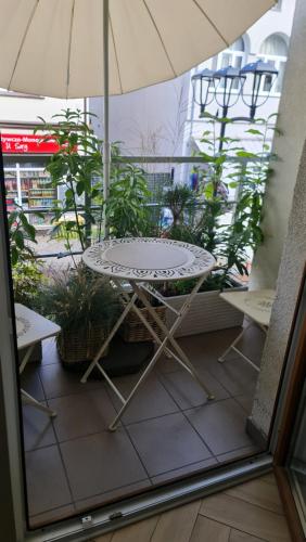 stół, krzesła i parasol na patio w obiekcie Apartament Międzyzdroje 2 osoby - Centrum Międzyzdrojów w mieście Międzyzdroje
