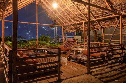 a pavilion with chairs and a table on a deck at night at Deck on the hills Bunks in Kandy