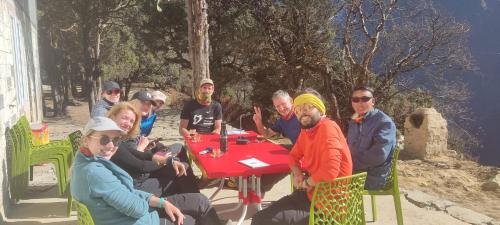 een groep mensen die rond een rode tafel zitten bij Trekker's Lodge 