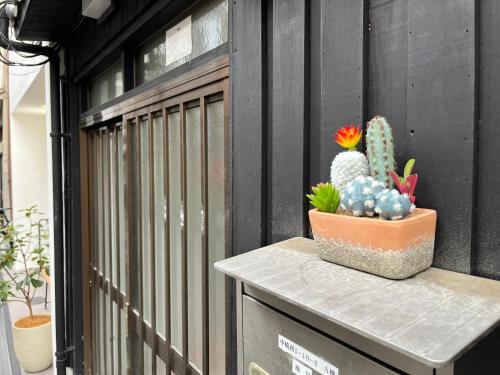 a plant sitting on top of a container on a fence at 中崎町駅3分/梅田徒歩圏 100㎡ 3階建独棟町屋まるまる貸切 /梅田/大阪駅 in Osaka